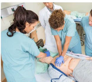 High angle view of nurses performing CPR on dummy patient while doctor standing by in hospital room