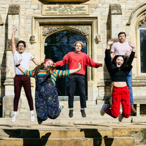 Students jumping outside cloisters