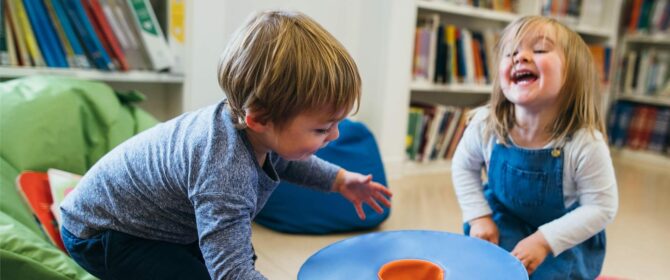 Two children playing some some large foam rings