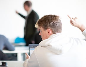 student in seminar with hand raised