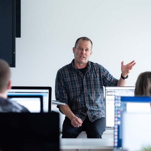 Explore global relationships Tutor teaching in a computer classroom
