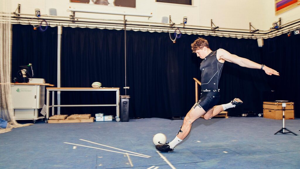 Biomechanics student striking a ball in the lab