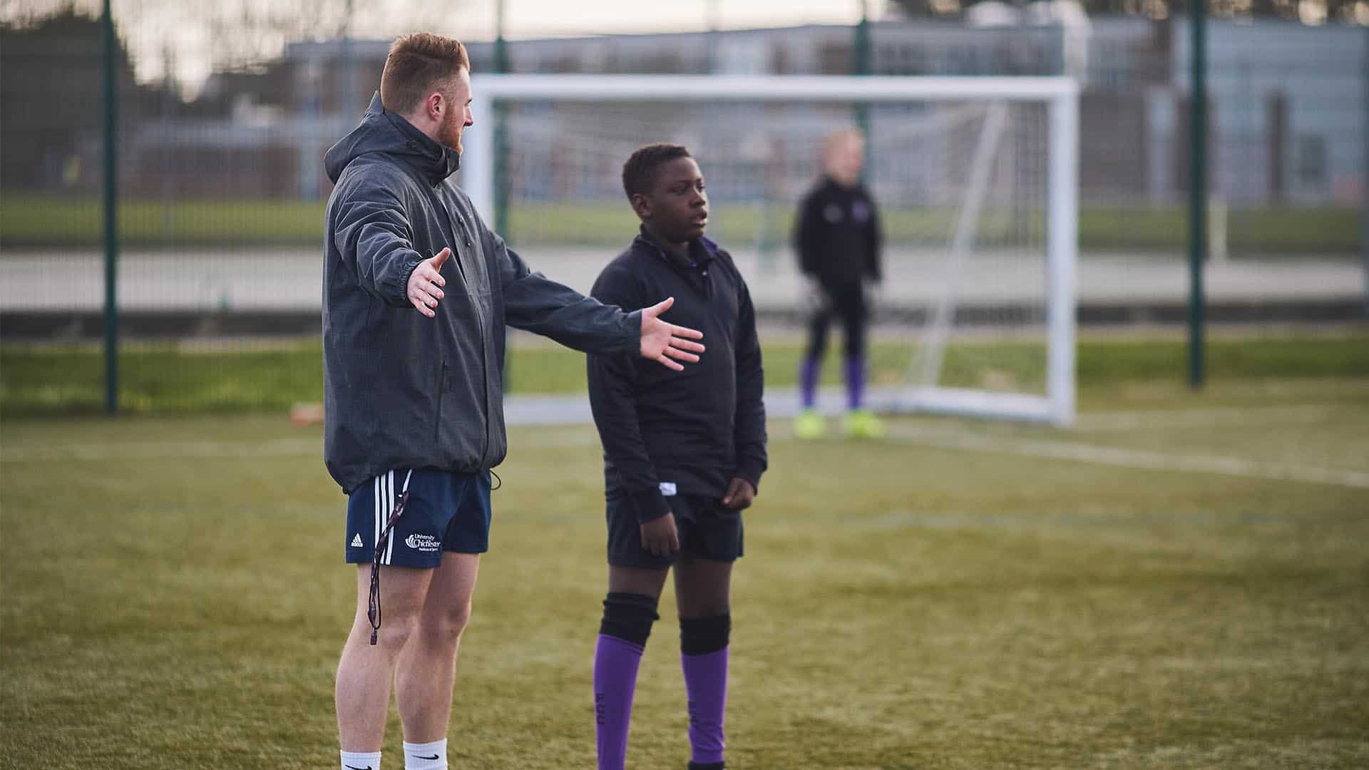 football coach helping student