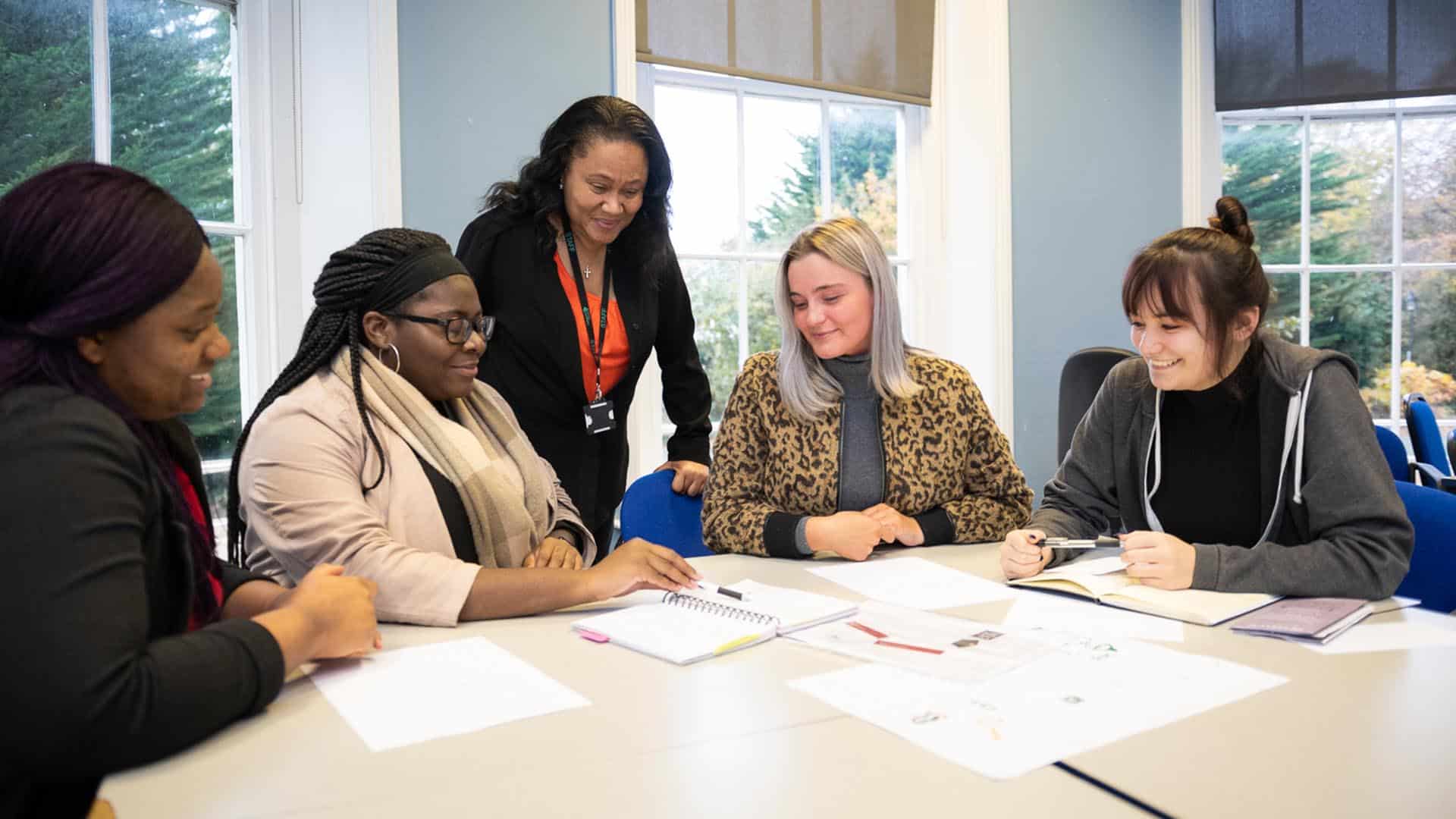 19 Business 1920x1080 30 teacher helping business students with group work
