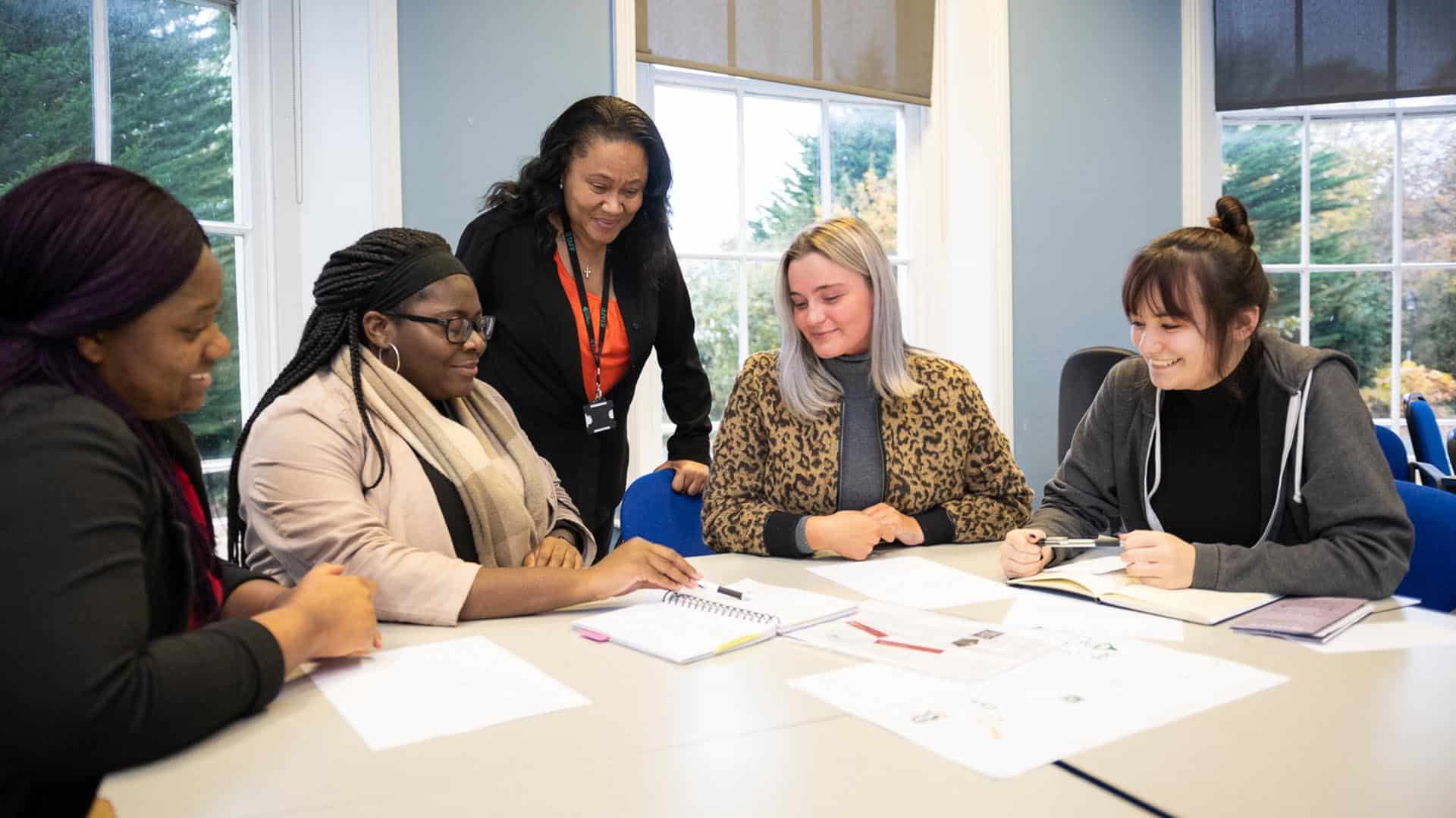 teacher helping business students with group work