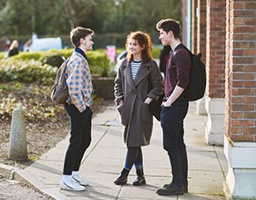 three students talking and standing outside the LRC