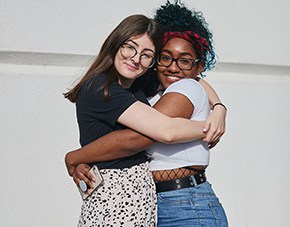 two students hugging and smiling