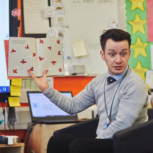 teacher reading storybook to primary school class