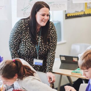 teacher helping pupils with their classwork