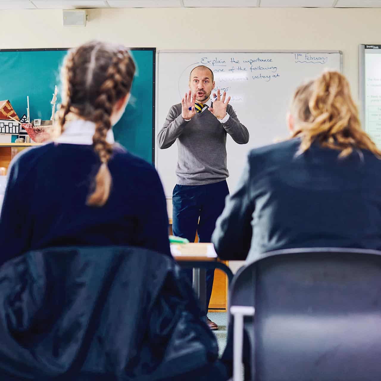 A physics teacher leading a classroom