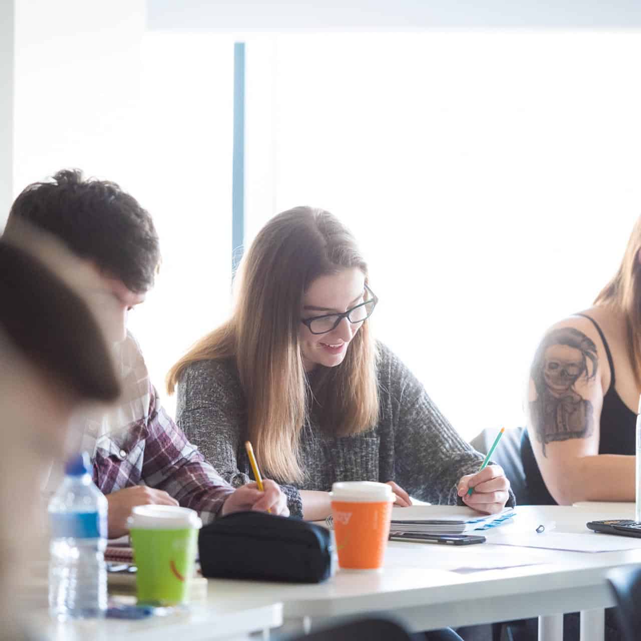 students sitting in classroom writing notes