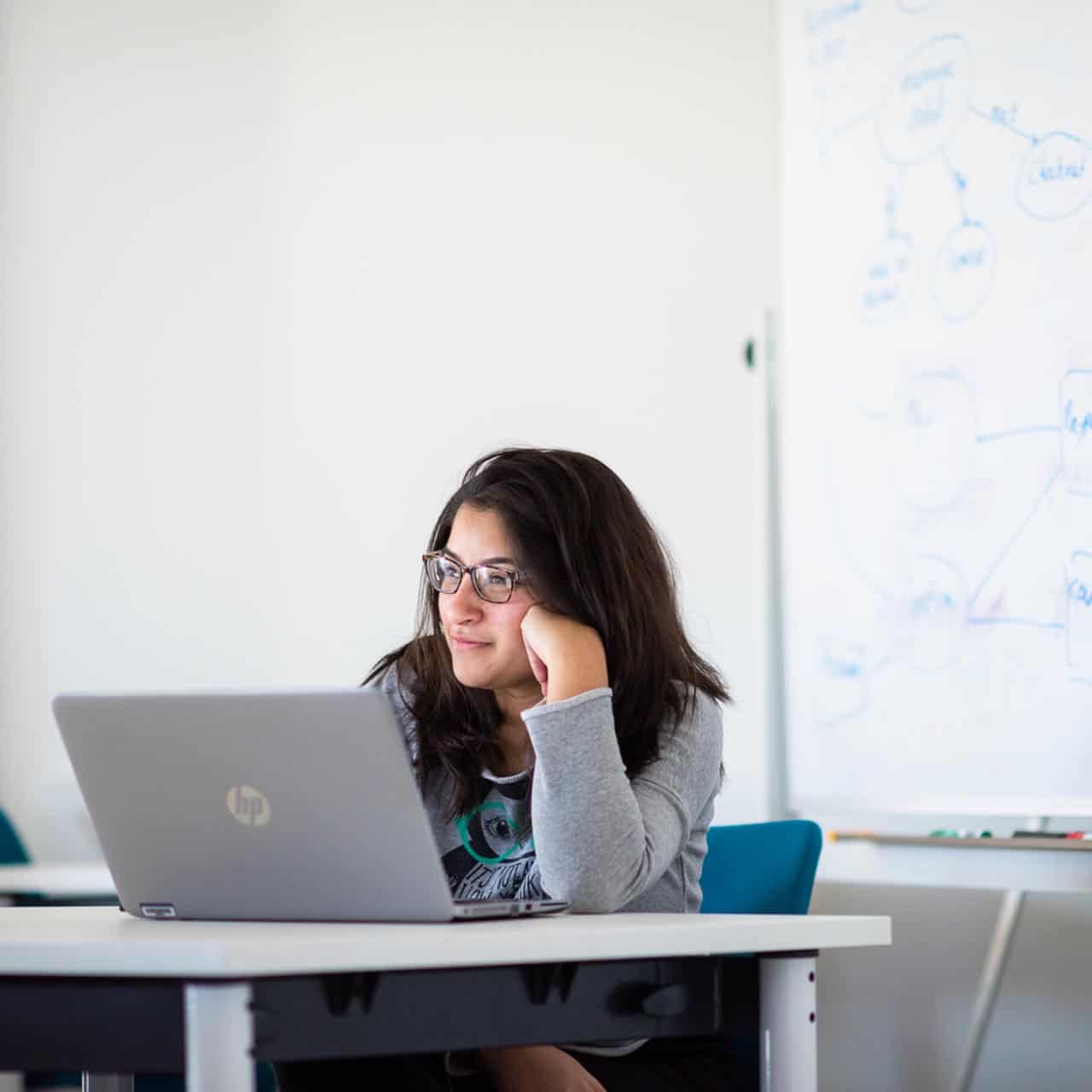 Business student sitting in seminar on laptop