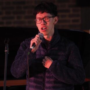 Student singing on stage with microphone