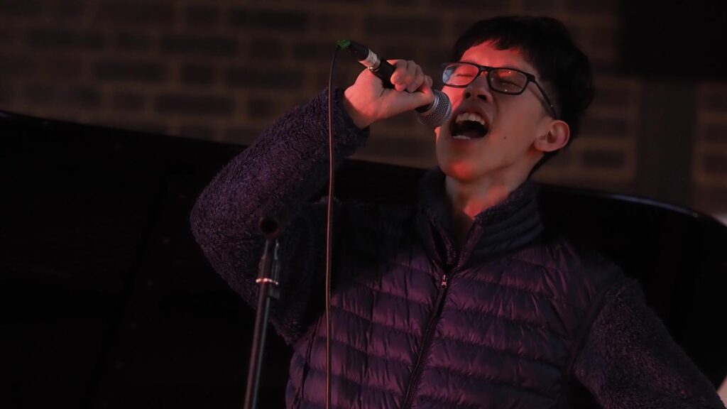 Student performing on stage with microphone