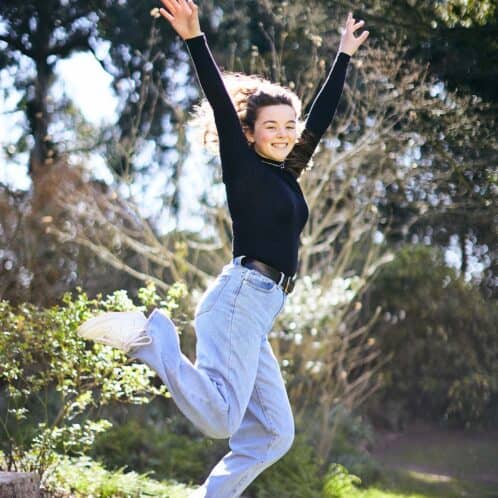 Jumping smiling student outside