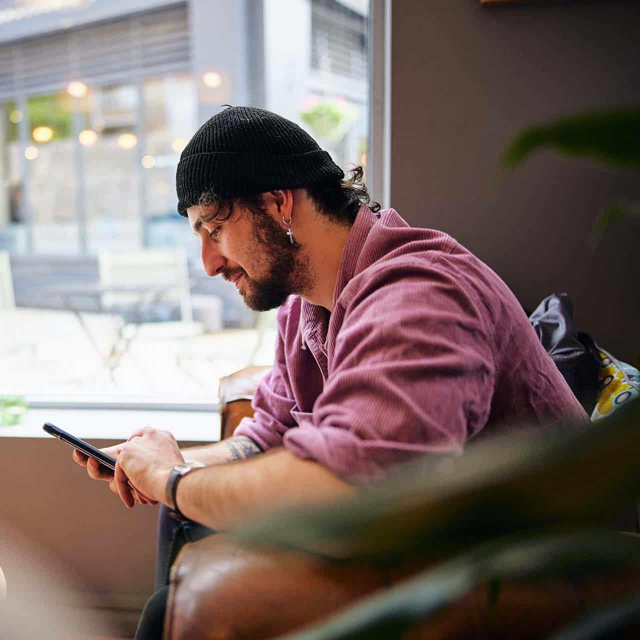 student sitting in cafe using phone