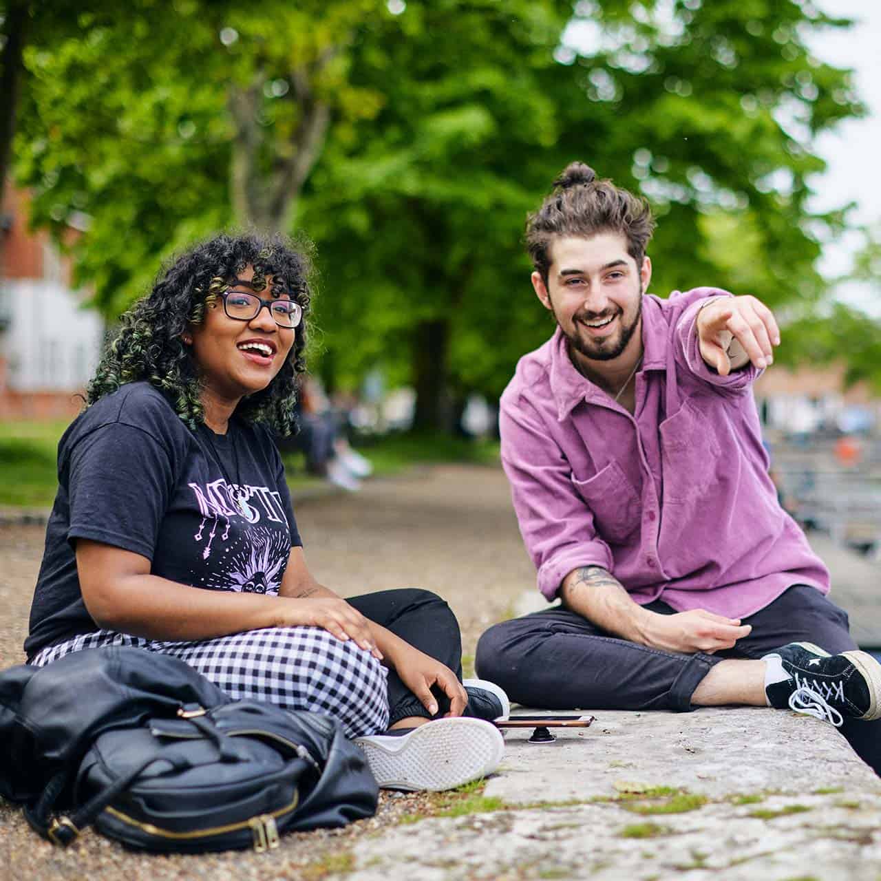 two students sitting by canal in Chichester