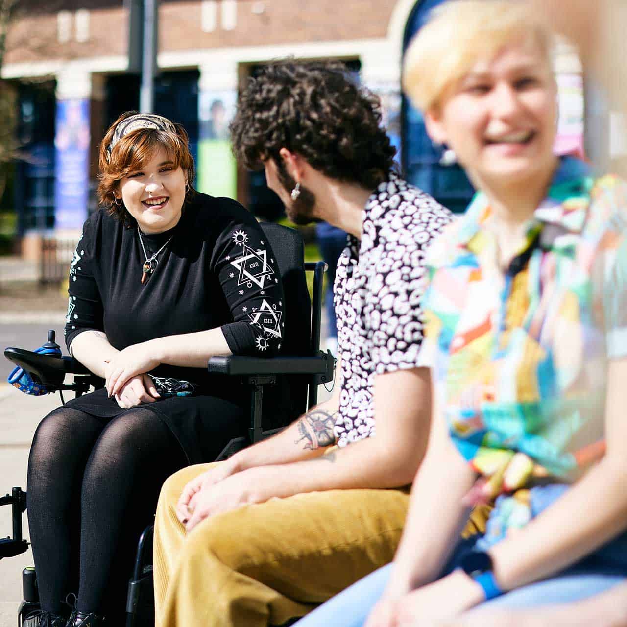 Students laughing and chatting outside of Academic Block