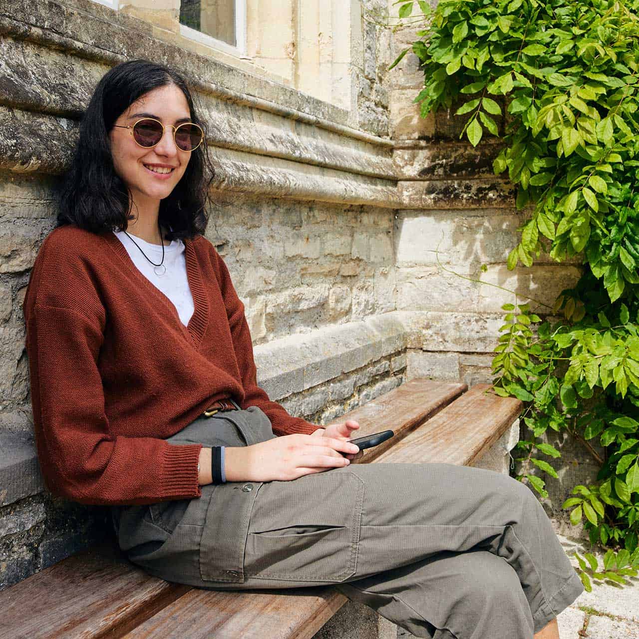 21+ Students BOC 1280 X 1280 14 Student wearing sunglasses sat by Cloisters