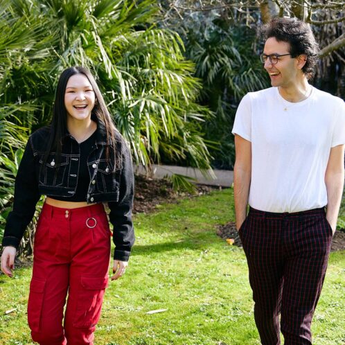 two students walking and laughing on campus