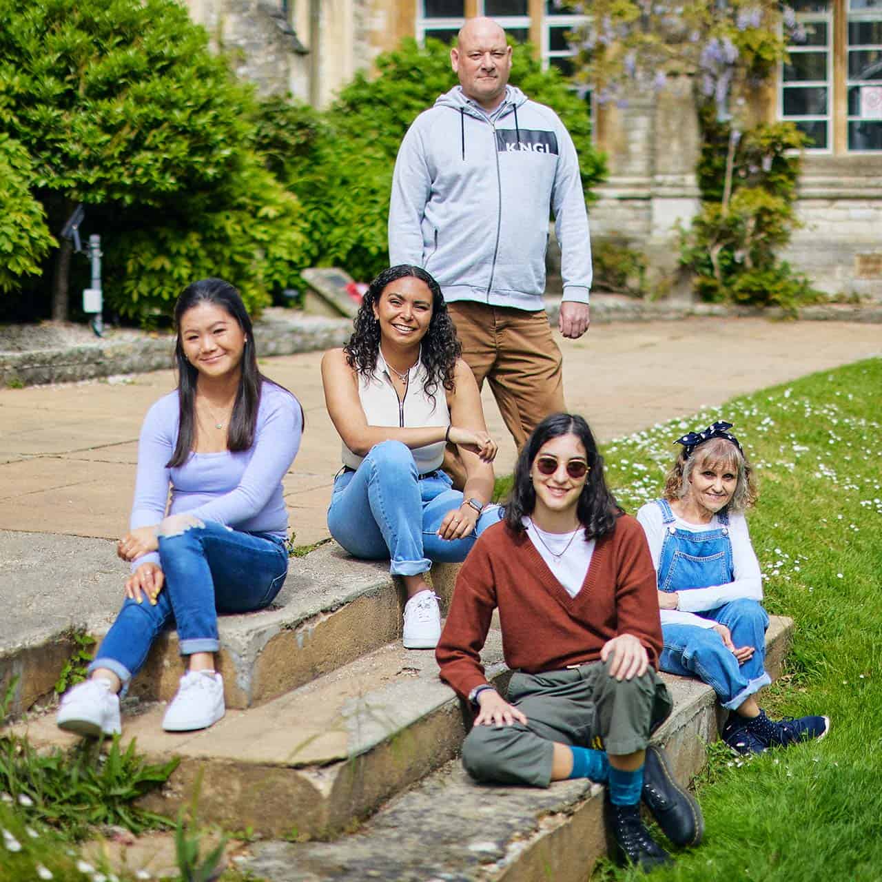 five students sitting on Cloisters lawn