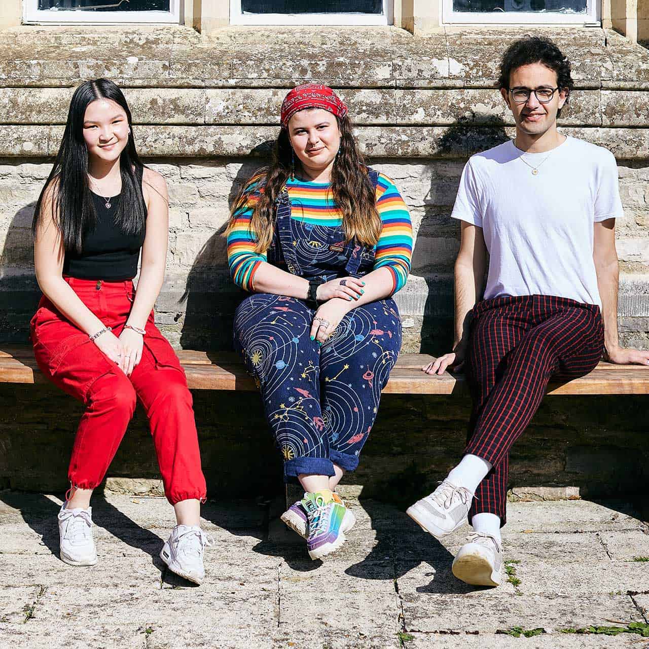 Students sat on bench outside Cloisters