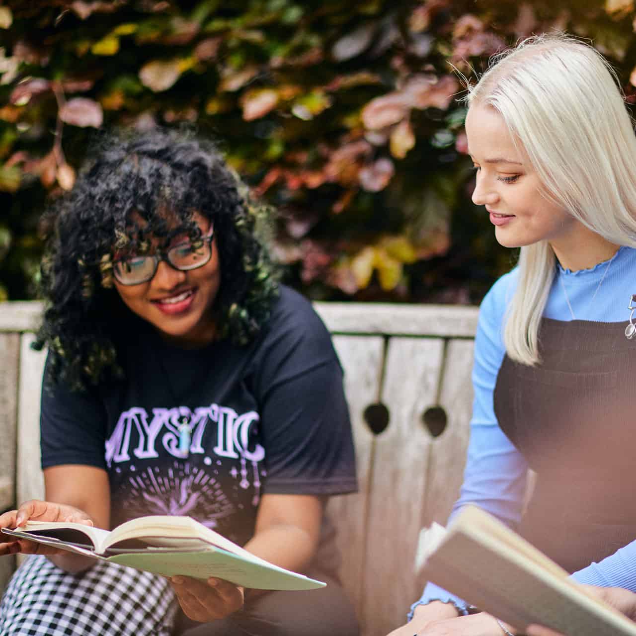 students reading a book in the park