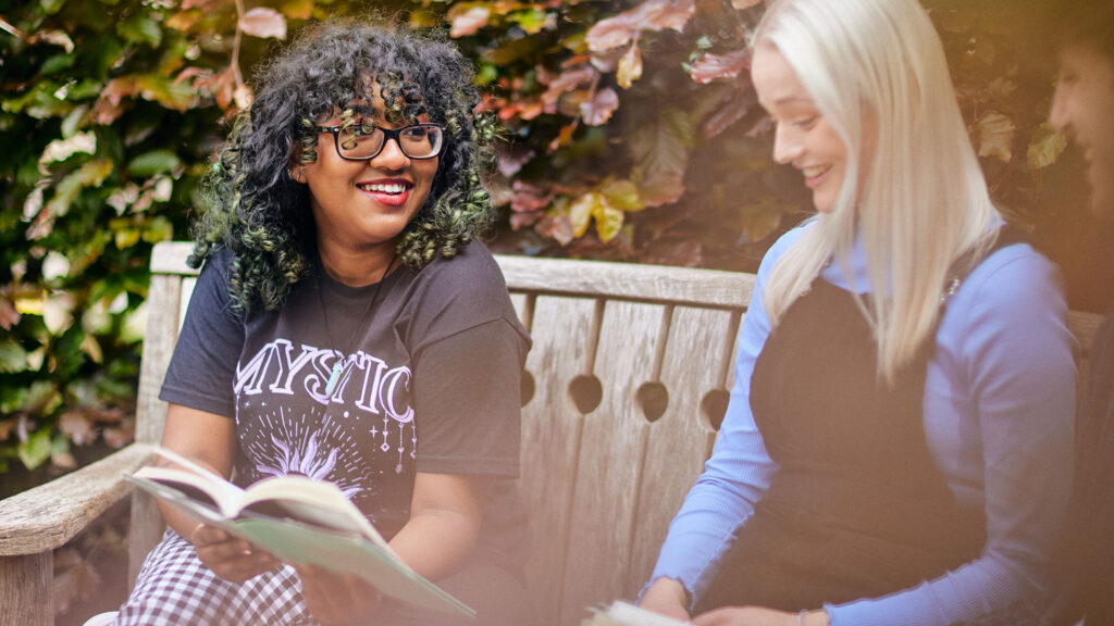 students reading a book in the park