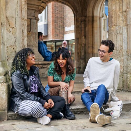 Students sat outside Chichester Cross