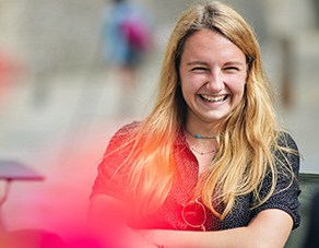 female student sitting outside smiling