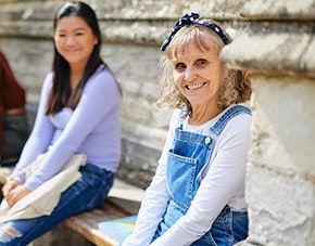 mature student sitting outside Cloisters