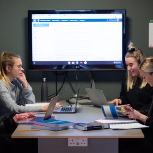 Students studying in group room with screen