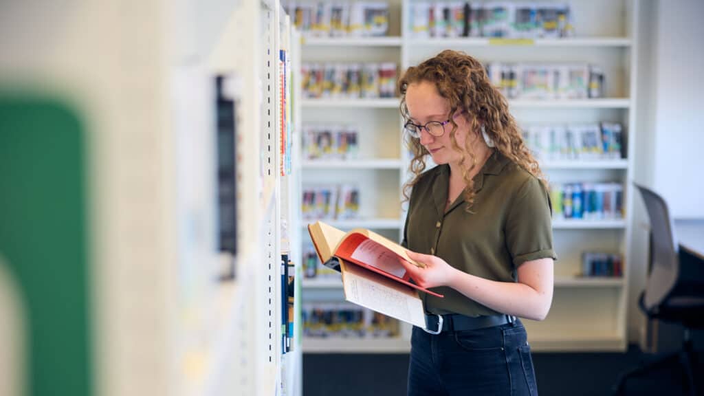 Student reading a book in the library