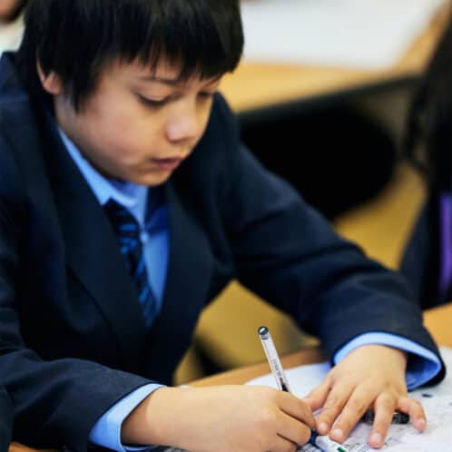 young school pupil writing