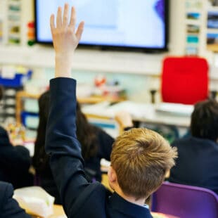 student in class raising his hand