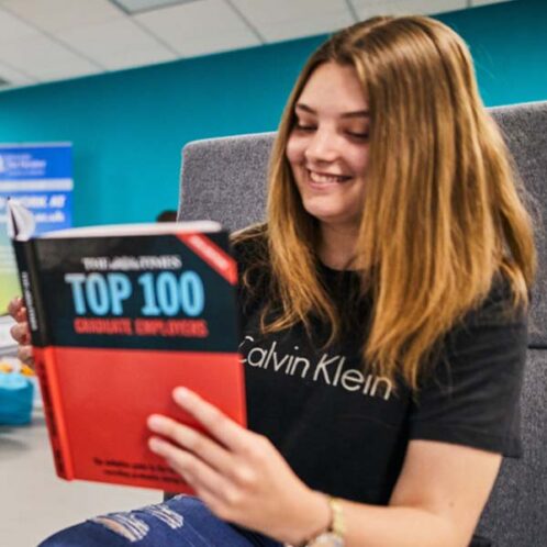 A student reading a book of the Top 100 graduate employers