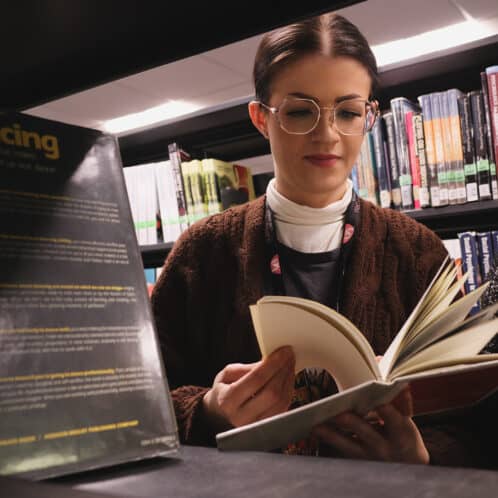 Dance student reading book in library