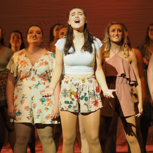 Students performing under spotlight