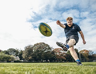 Rugby player kicking ball