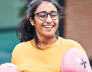 Woman wearing pink boxing gloves