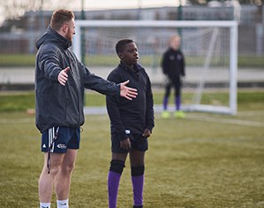 Coach explaining to student on pitch