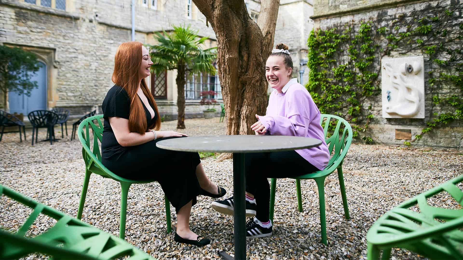 students sitting on a table outside and talking