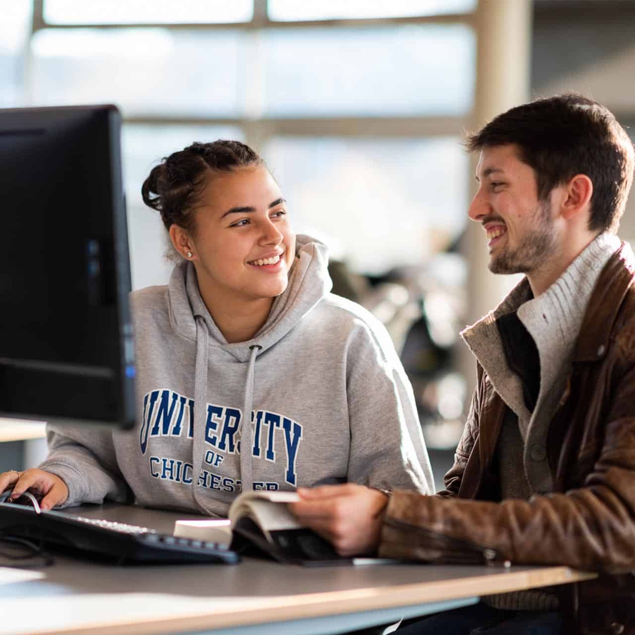 students in the library working at computers