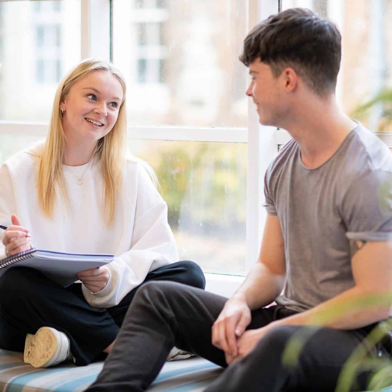 Two students sat together in Cloisters