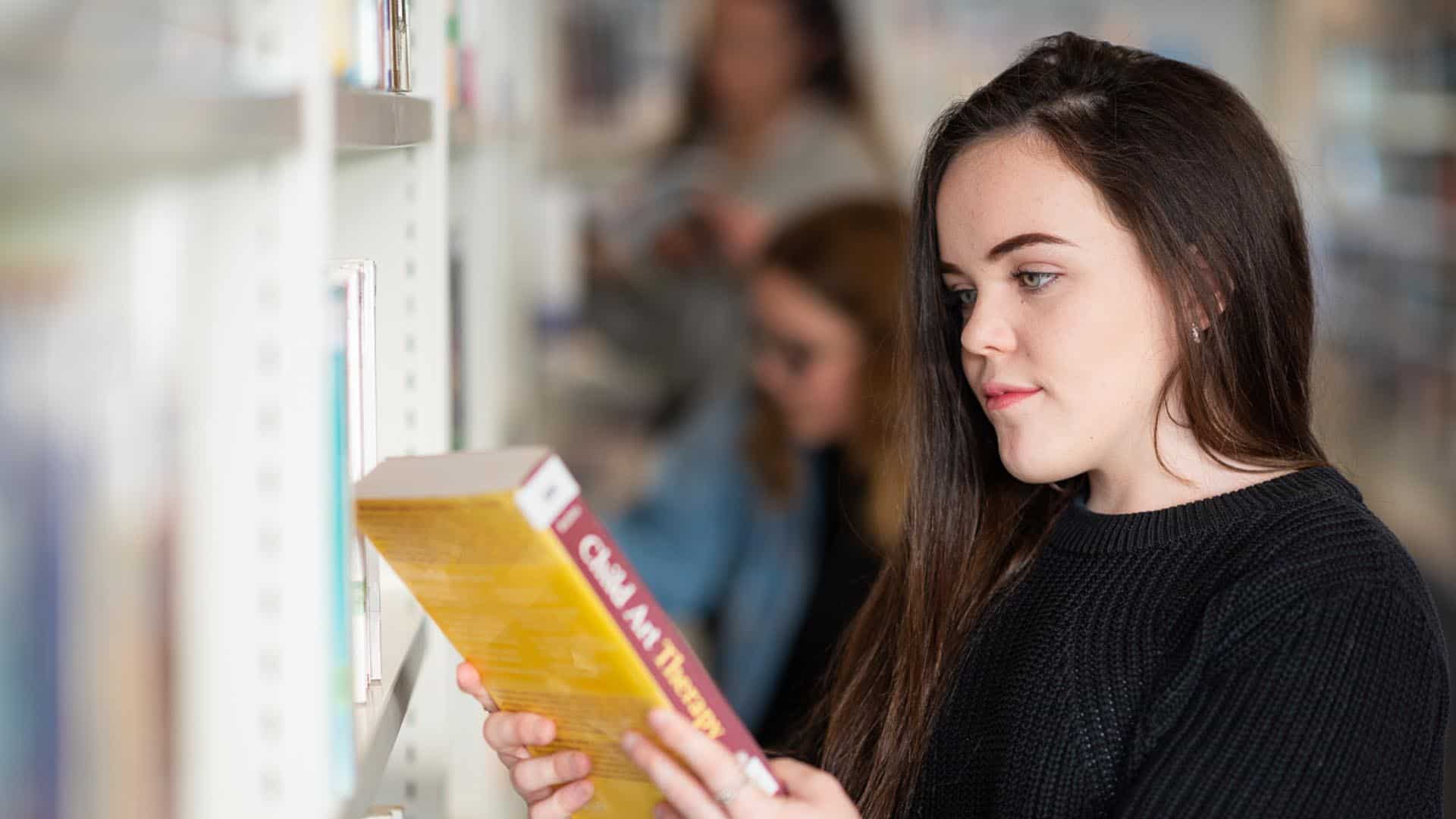 student reading book in library