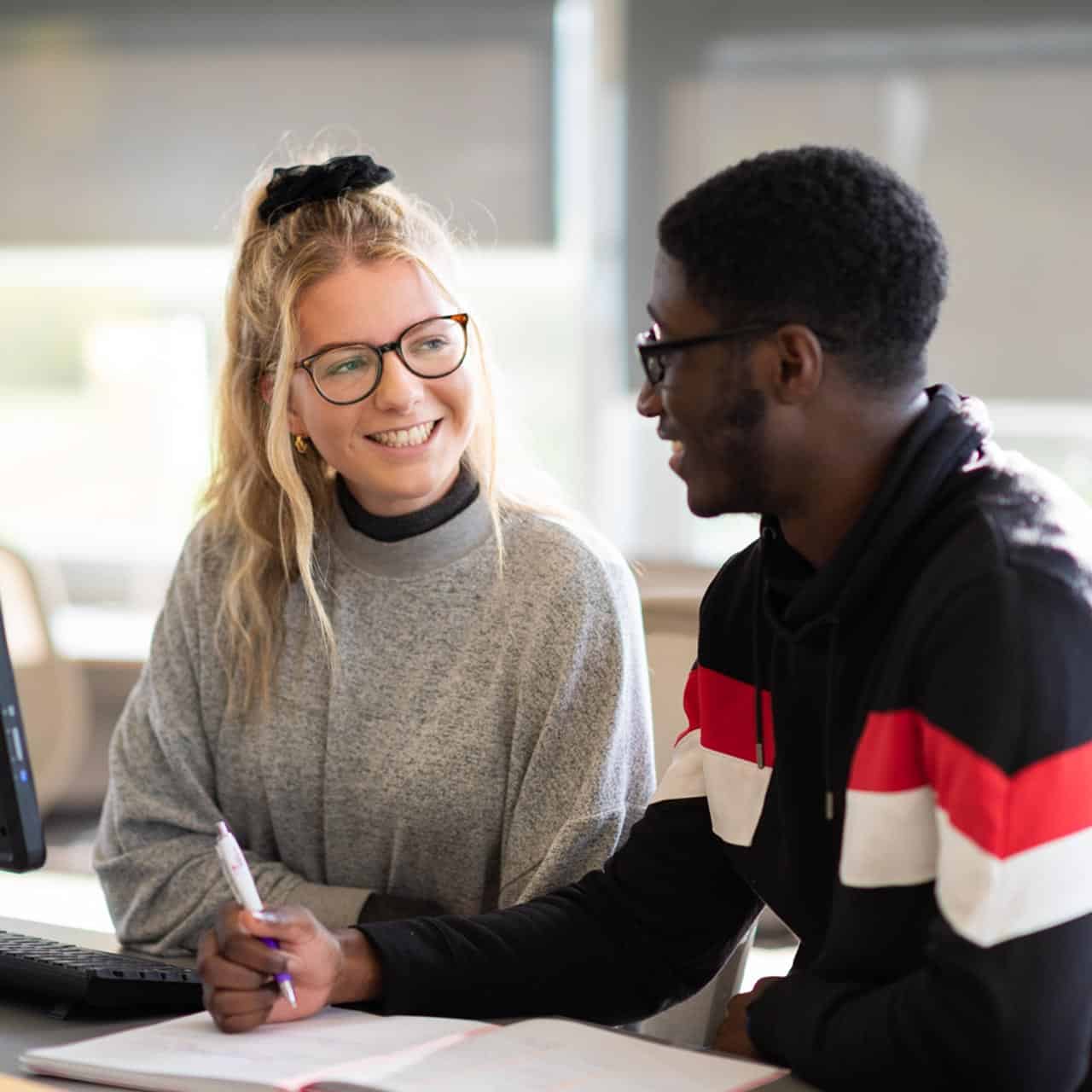 students in library doing work on a computer