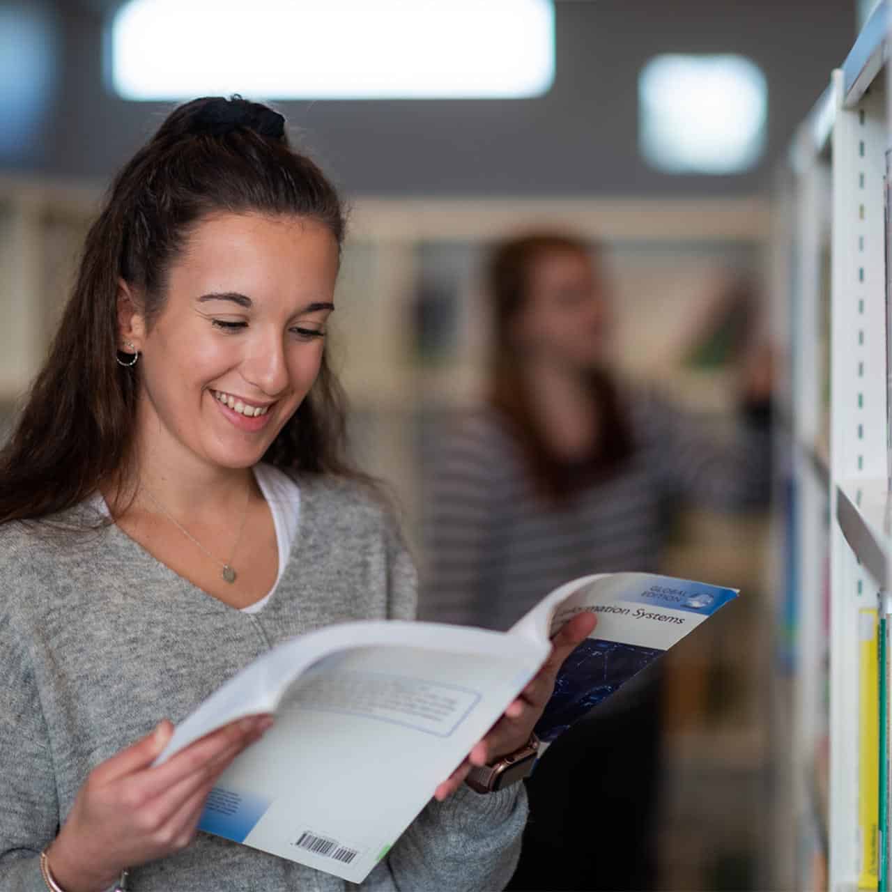 Female student browsing book in library