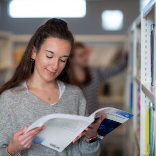 Female student browsing book in library
