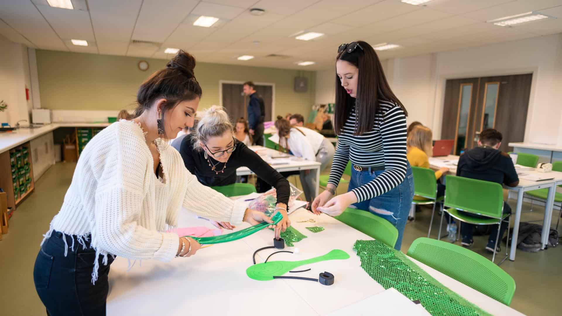 Students making something green at desk