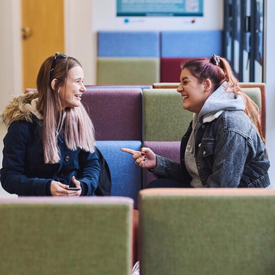 20 Students 1280 X 1280 2 Students chatting on University sofas